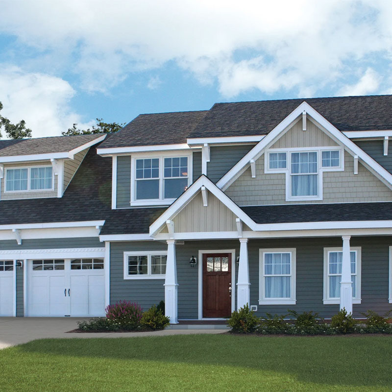 Large house with green lawn and blue sky
